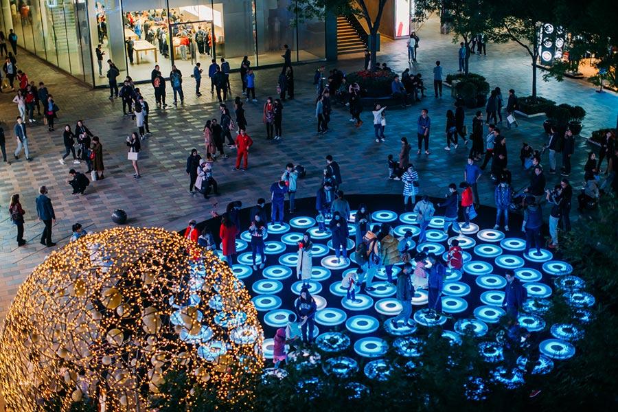 Art works by light artists and art teams from across the world have turned Beijing\'s Sanlitun area, the city\'s iconic fashion hub, into a luminous world with an ongoing light festival. (Photo provided to China Daily)

The light festival, which runs through Nov. 5, is an annual event organized by Taikooli Sanlitun since 2014.

It aims to present a visual feast for visitors and shoppers.

Entitled Lights Play, the festival this year features four large-scale outdoor interactive lighting installations.

New York-based interactive artist Jen Lewin\'s iconic work The Pool is being exhibited for the first time in China. It consists of 106 LED-lit circle platforms on the ground that change color when people step on them.

Angels is a series of luminous wings and halos co-produced by German artist Gaston Zahr and Israeli artist Merav Eitan.

The other two light installations have lots of flowers — either hanging from trees or showcased along the street.

According to Yu Guo\'an, the general manager of Taikooli Sanlitun, the area was one of the first shopping centers in China to introduce a light festival that features well-known international artists every year.

He says Sanlitun also keeps a keen eye on art and culture.

And the area is also supporting this year\'s Beijing International Music Festival, which runs until Oct 28. An exhibition center in Sanlitun is hosting operas as part of the music festival.