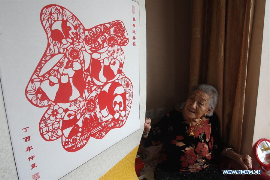 Lin Guimao, 103, makes papercuttings at home in Yantai City, east China's Shandong Province, Aug. 30, 2017. Lin learned papercutting skills as a child, and now still enjoys the hobby. (Xinhua/Shen Jizhong)