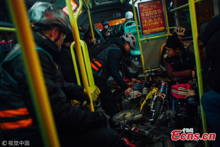 Passengers, mostly chauffeurs, ride a bus for free in Wuhan City, the capital of Central China’s Hubei Province, Feb. 7, 2018. Chauffeurs see an increase in demand for their services as more car owners drink more alcohol at dinners and parties ahead of Spring Festival, China’s Lunar New Year. Chauffeurs usually ride their folding bicycles to restaurants and entertainment venues, pick customers up there, and drive them home in their own cars. Some can earn up to 800 yuan ($120) over one night for the service. (Photo/VCG)