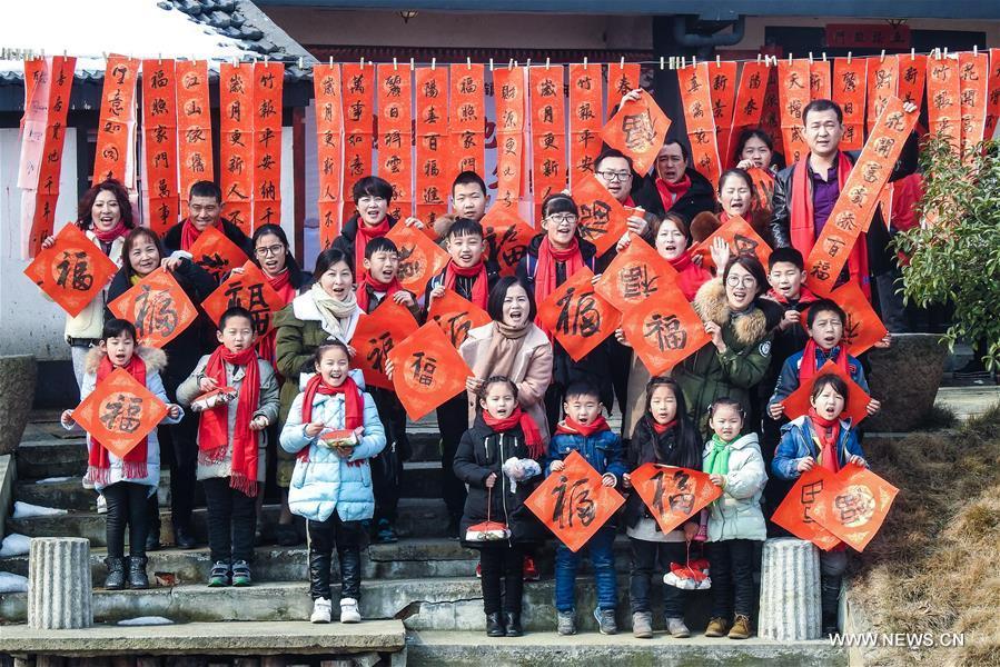 Photo taken on Feb. 8, 2018 shows children of migrant workers with big red paper featuring chinese character \