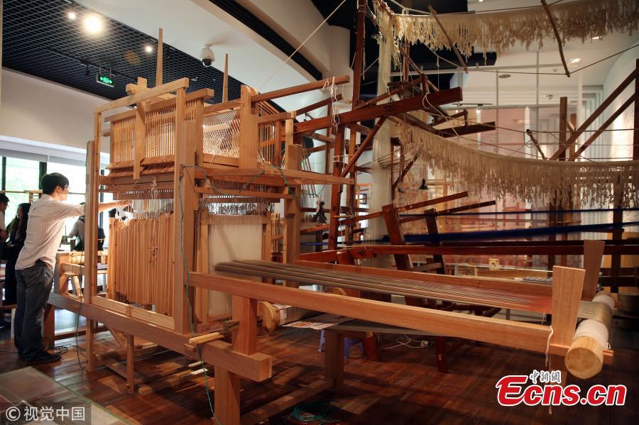 A replica of a colorful brocade embroidered with the text “Wuxing Chu Dongfang Li Zhongguo”, which literary means \
