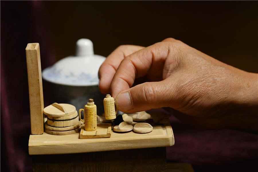 Chen Hesheng shows a miniature thermos which is as big as a fingernail.  (Photo/Asianewsphoto)

Chen Hesheng, 69, is a local Nanjing resident whose predecessors have lived there for 300 years. After his retirement, he picked up carpentry.

Every morning the first place he goes to is his workshop. At first he made some small wooden spoons and scoops, and then created miniature wooden farm tools and utensils. Later, Chen turned his focus to fast disappearing professions. He said that he wants to preserve the old memories as many old professions are disappearing.