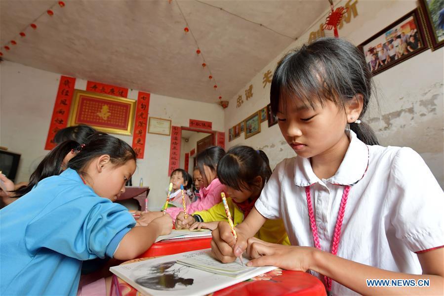 Children do homework at the caring station for left-behind children at Miao Yanxiang\'s home in Shibu Town, Nanchang City of east China\'s Jiangxi Province, May 23, 2018. Miao, over 70, established a caring station for left-behind children at his own house in 2009, where he provided free place for children to do homework and study after school. Having received more than 3,000 children over the past nine years, Miao is satisfied with his voluntary work as he see the progress of the children. (Xinhua/Peng Zhaozhi)