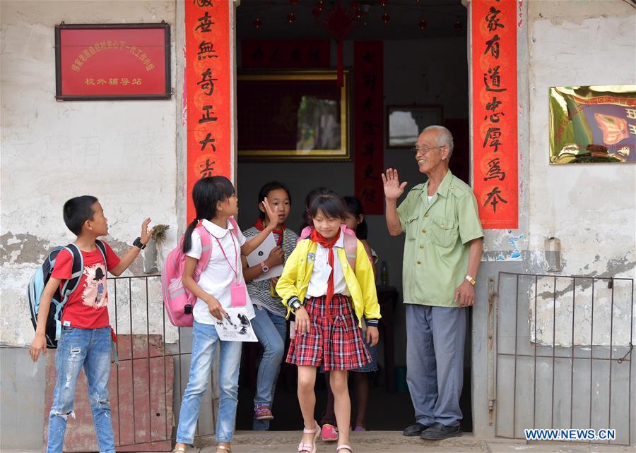 Miao Yanxiang farewells children at the caring station for left-behind children at his home in Shibu Town, Nanchang City of east China\'s Jiangxi Province, May 23, 2018. Miao, over 70, established a caring station for left-behind children at his own house in 2009, where he provided free place for children to do homework and study after school. Having received more than 3,000 children over the past nine years, Miao is satisfied with his voluntary work as he see the progress of the children. (Xinhua/Peng Zhaozhi)