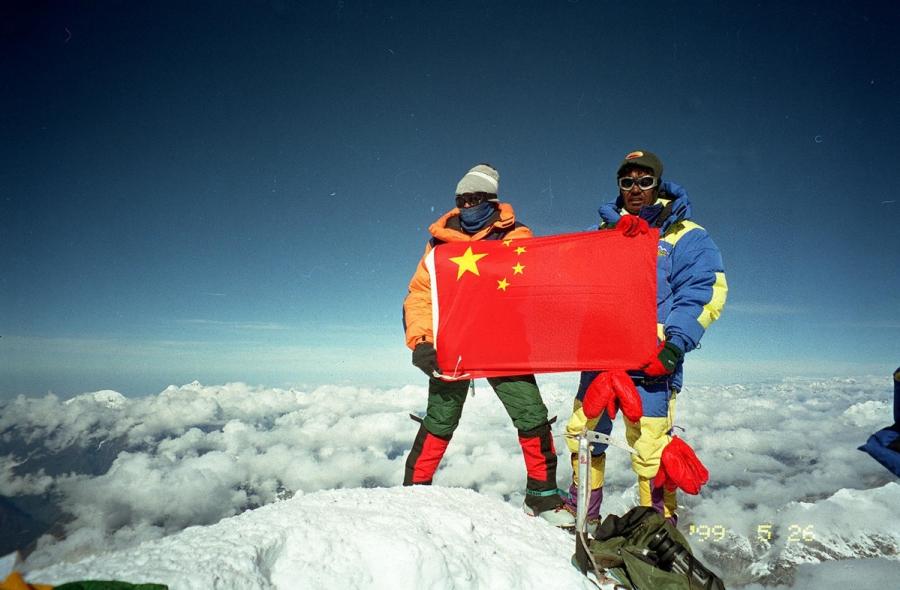Rinna and Jiji pose on the peak of Mount Qomolangma with Chinese flag on May 27, 1999. They ignited the torch of the 6th National Minority Traditional Sports Games. Rinna and Jiji were the first Chinese couple to reach Mount Qomolangma. (Photo/Xinhua)