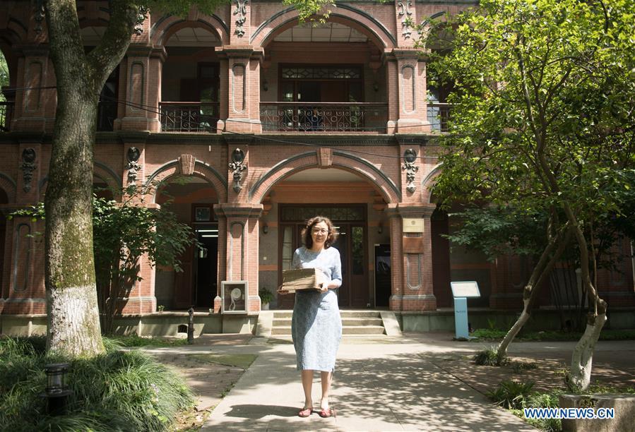 Yan Jingshu poses for photo in front of the ancient book restoration center of Zhejiang Library in Hangzhou, east China\'s Zhejiang Province, May 23, 2018. Yan, 55, has worked in the national level ancient book restoration center of the library for 38 years. She and her colleagues collected more than 200 types of paper to restore ancient books. (Xinhua/Weng Xinyang)