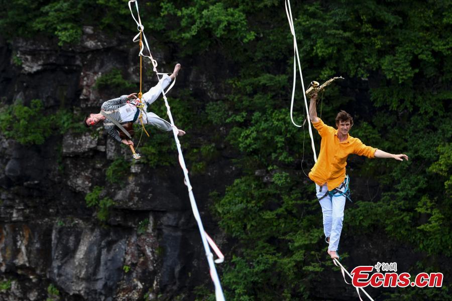 Members of the band HouleDouse perform on slacklines across the 1,400-meter-high cliffs of Tianmen Mountain in Zhangjiajie National Forest Park in central China\'s Hunan province, on Wednesday, May 23, 2018. HouleDouse have made their Asian debut in China, in a show that combines extreme sports with music. (Photo: China News Service/ Yang Huafeng)