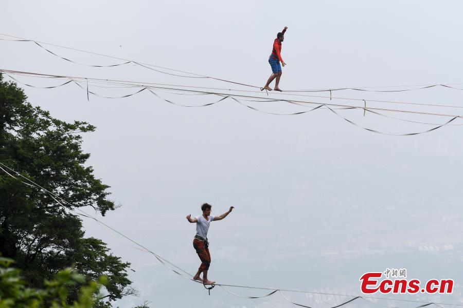 Members of the band HouleDouse perform on slacklines across the 1,400-meter-high cliffs of Tianmen Mountain in Zhangjiajie National Forest Park in central China\'s Hunan province, on Wednesday, May 23, 2018. HouleDouse have made their Asian debut in China, in a show that combines extreme sports with music. (Photo: China News Service/ Yang Huafeng)