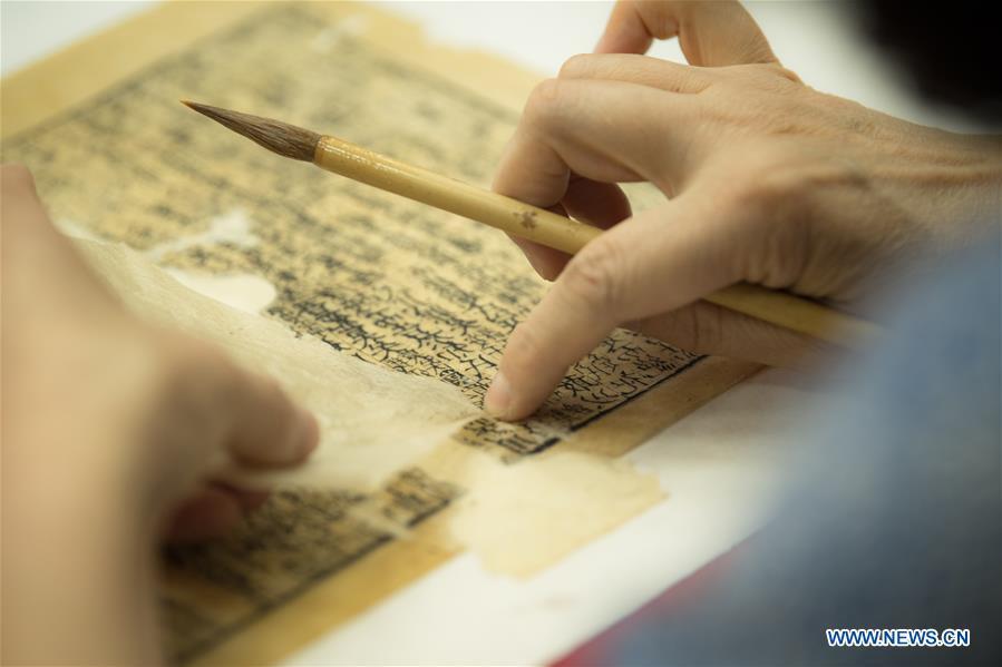 Yan Jingshu restores an ancient book at Zhejiang Library in Hangzhou, east China\'s Zhejiang Province, May 23, 2018. Yan, 55, has worked in the national level ancient book restoration center of the library for 38 years. She and her colleagues collected more than 200 types of paper to restore ancient books. (Xinhua/Weng Xinyang)