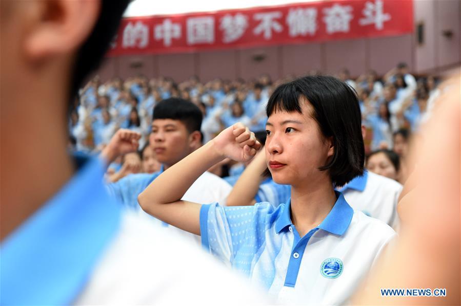 Volunteers take an oath during a launch ceremony for the volunteer program for the upcoming Shanghai Cooperation Organization (SCO) summit in Qingdao, east China\'s Shandong Province, May 24, 2018. About 2,000 volunteers will offer services such as assisting with guests\' arrival and departure, translation, and media requests during the 18th summit of the SCO. (Xinhua/Li Ziheng)