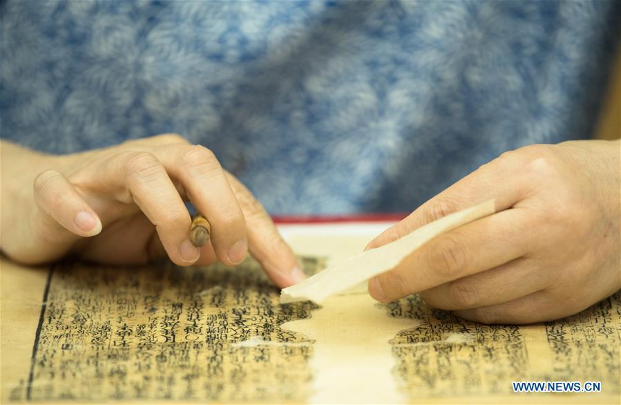 Yan Jingshu restores an ancient book at Zhejiang Library in Hangzhou, east China\'s Zhejiang Province, May 23, 2018. Yan, 55, has worked in the national level ancient book restoration center of the library for 38 years. She and her colleagues collected more than 200 types of paper to restore ancient books. (Xinhua/Weng Xinyang)