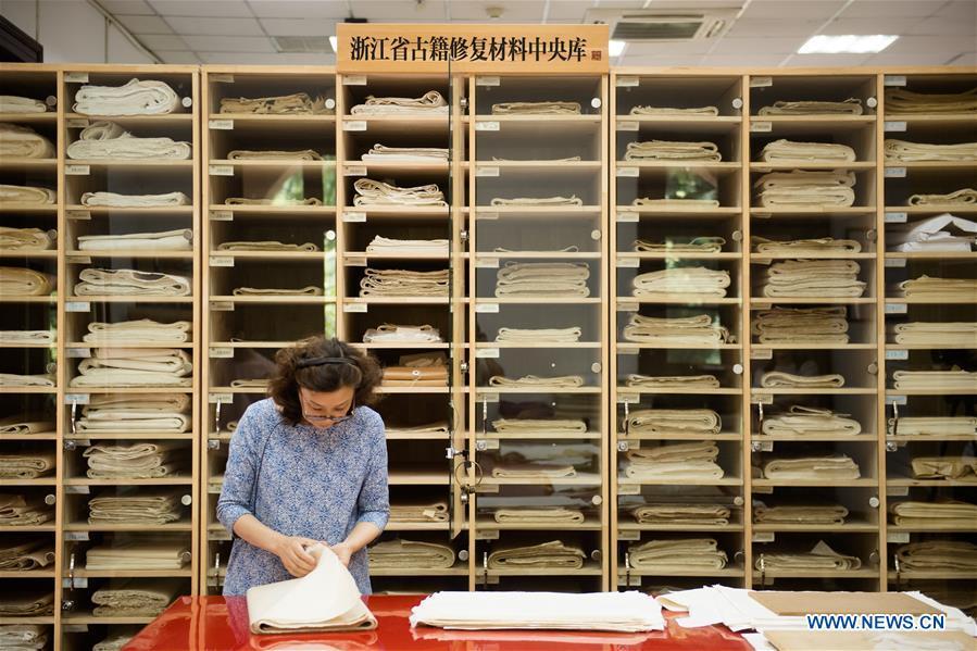 Yan Jingshu selects restoration paper at Zhejiang Library in Hangzhou, east China\'s Zhejiang Province, May 23, 2018. Yan, 55, has worked in the national level ancient book restoration center of the library for 38 years. She and her colleagues collected more than 200 types of paper to restore ancient books. (Xinhua/Weng Xinyang)