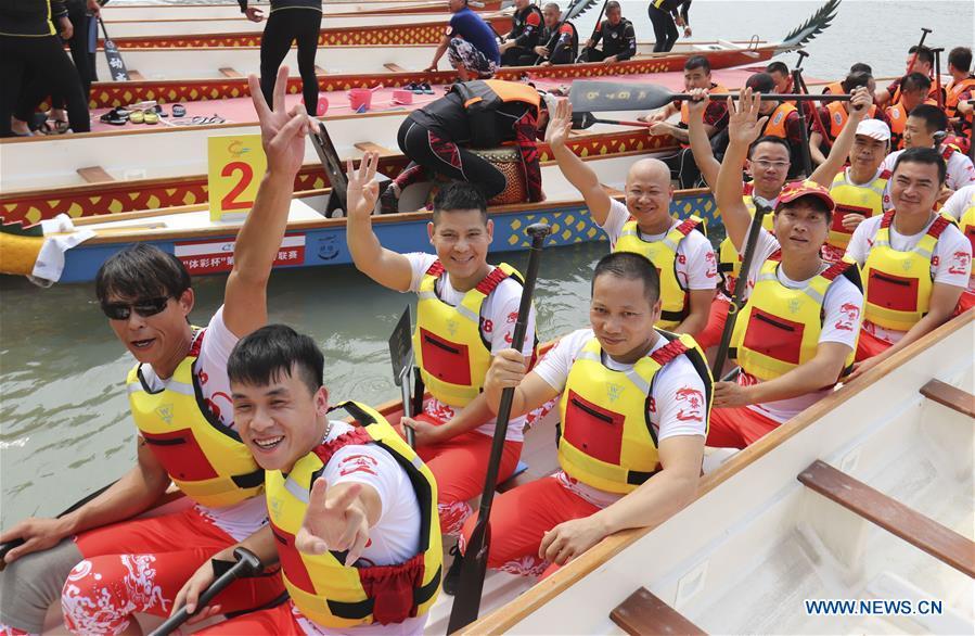 Contestants wave hands before a dragon boat match at a water park of Huichang lake in Wenzhou, east China\'s Zhejiang Province, May 26, 2018. (Xinhua/Su Qiaojiang)