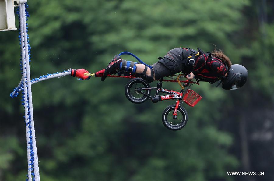 An enthusiast goes bungee jumping from Zhangjiajie Grand Canyon\'s glass-bottom bridge, during a challenge in Zhangjiajie scenic spot, central China\'s Hunan Province, May 26, 2018. Enthusiasts from Russia, Australia, Britain and other countries and regions participated in the challenge on Saturday. (Xinhua/Zhou Guoqiang)