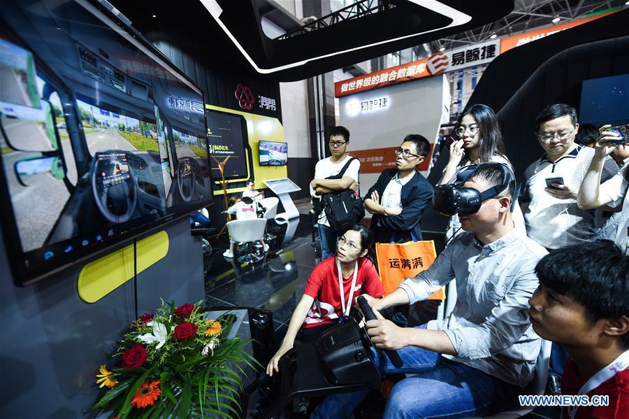 A visitor experiences virtual reality driving during the 2018 China international big data industry expo in Guiyang, Southwest China\'s Guizhou province, May 26, 2018. (Photo/Xinhua)