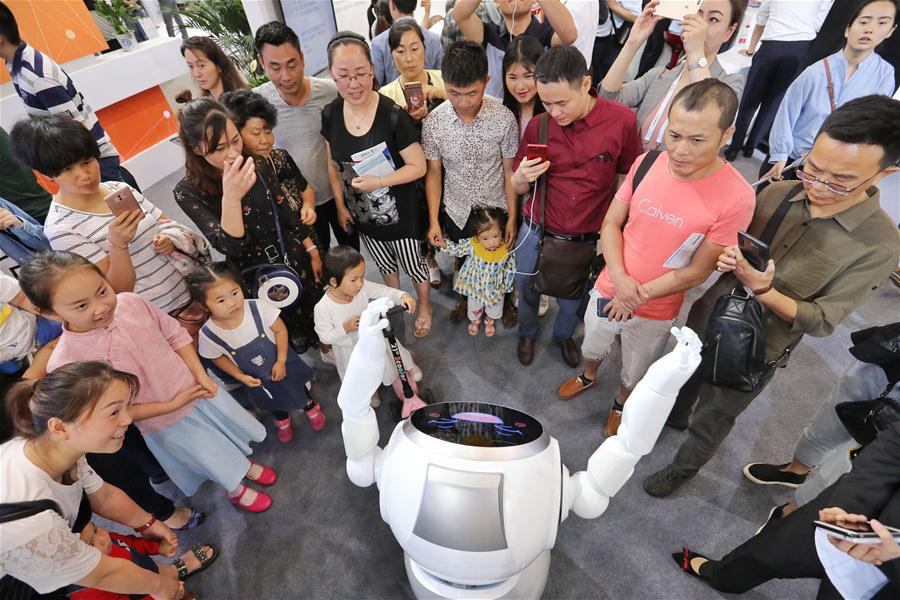 Visitors watch robot dancing during the 2018 China international big data industry expo in Guiyang, Southwest China\'s Guizhou province, May 26, 2018. (Photo/Xinhua)