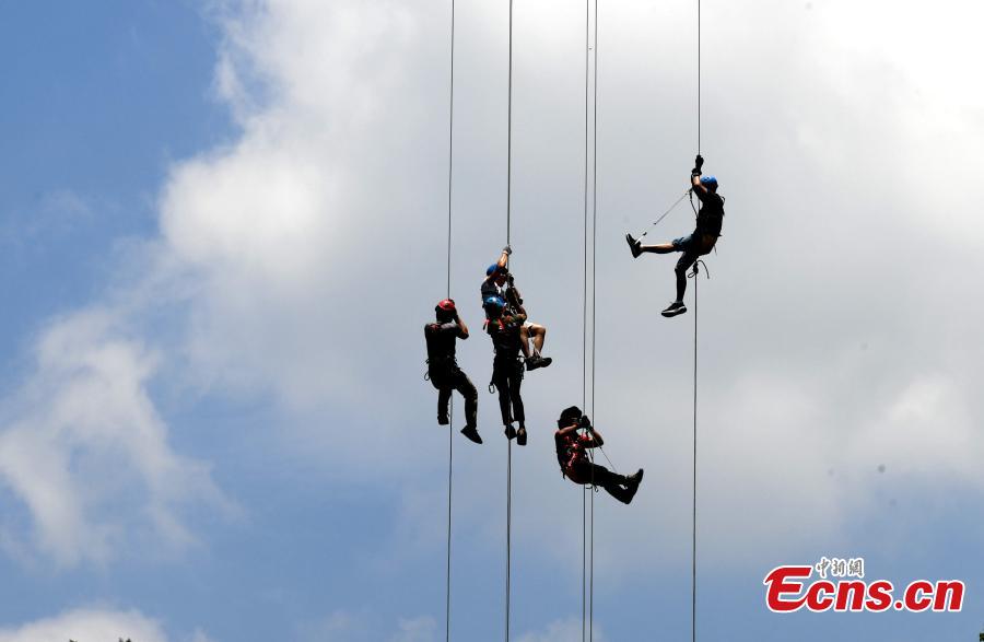 Extreme sports enthusiasts take on the challenge of descending from and then climbing back to a suspended glass bridge 188 meters above the ground at a scenic spot in Youxi County, East China’s Fujian Province, May 26, 2018. More than 20 participants fast-roped down and then climbed back up from under the bottom of the bridge. (Photo: China News Service/Wang Dongming)