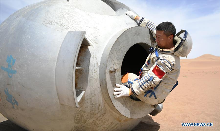 Taikonaut Liu Wang exits from a re-entry capsule during a wilderness survival training in the Badain Jaran Desert in northwest China\'s Gansu Province, May 17, 2018. Fifteen Chinese taikonauts have just completed desert survival training deep in the Badain Jaran Desert near Jiuquan Satellite Launch Center in northwest China. Organized by the Astronaut Center of China (ACC), the program was designed to prepare taikonauts with the capacity to survive in the wilderness in the event their re-entry capsule lands off target. (Xinhua/Chen Bin)