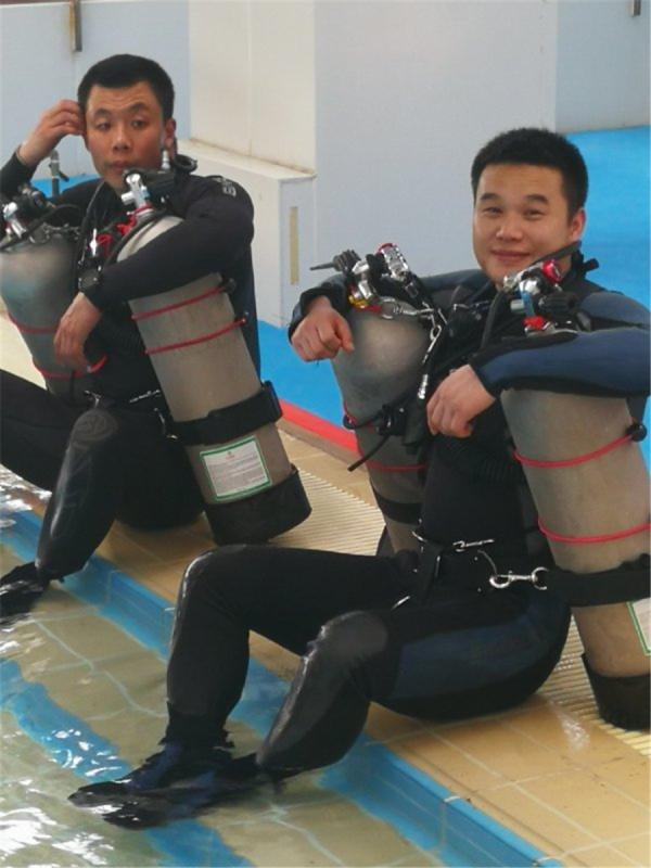 Chen Chao (left) and one of his colleagues take a break after a training session. (Photo provided to China Daily)

Chen Chao, who became a police diver in 2007, said a newcomer could learn diving techniques in just a year, but that was only part of the job, and the nature of the work meant that even a successful mission could leave squad members without a sense of accomplishment.

In 2011, Chen was assigned to search for the bodies of two children - a 5-year-old girl and a 6-year-old boy - who were killed and thrown in a river in downtown Beijing.

Chen, a sports graduate who learned how to swim at age 7, said it was the most haunting moment in his 11-year career and one he still remembers often.