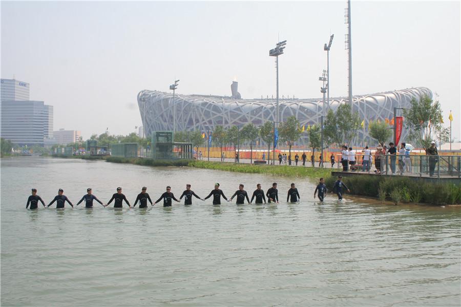 The squad\'s divers conduct security checks in the waterway beside Beijing\'s National Stadium. (Photo provided to China Daily)

\