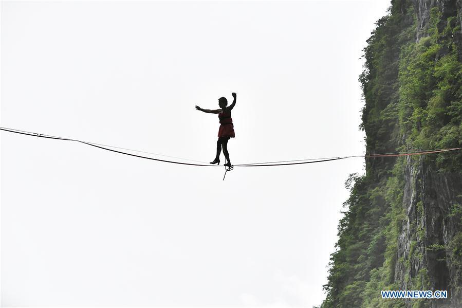 Mimi Guesdon of France participates in a slackline contest in high heels in Zhangjiajie, central China\'s Hunan Province, May 27, 2018. (Xinhua/Shao Ying)