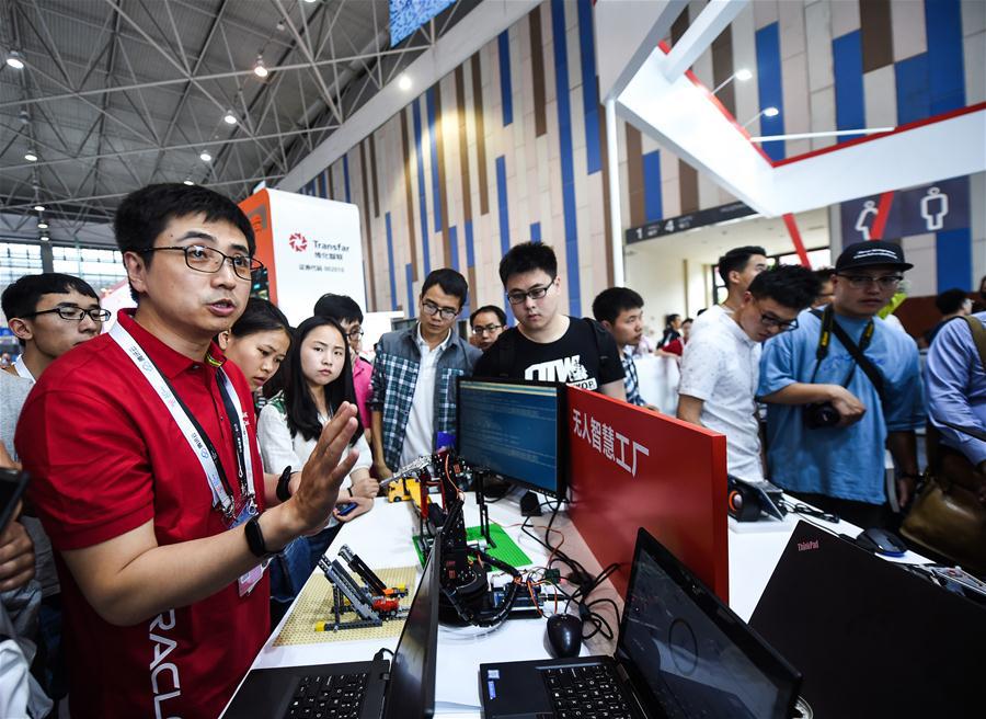 An engineer introduces an unmanned intelligent factory during the 2018 China international big data industry expo in Guiyang, Southwest China\'s Guizhou province, May 26, 2018. (Photo/Xinhua)