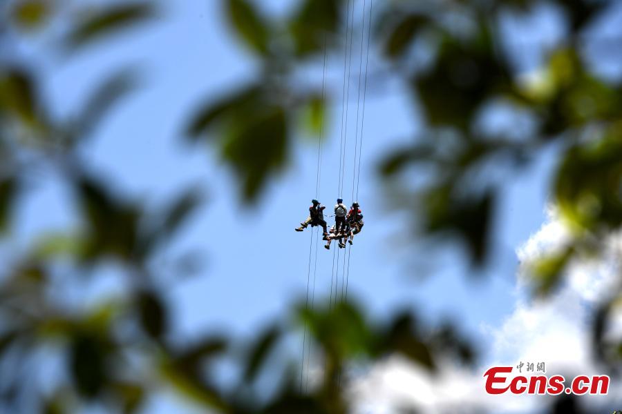 Extreme sports enthusiasts take on the challenge of descending from and then climbing back to a suspended glass bridge 188 meters above the ground at a scenic spot in Youxi County, East China’s Fujian Province, May 26, 2018. More than 20 participants fast-roped down and then climbed back up from under the bottom of the bridge. (Photo: China News Service/Wang Dongming)