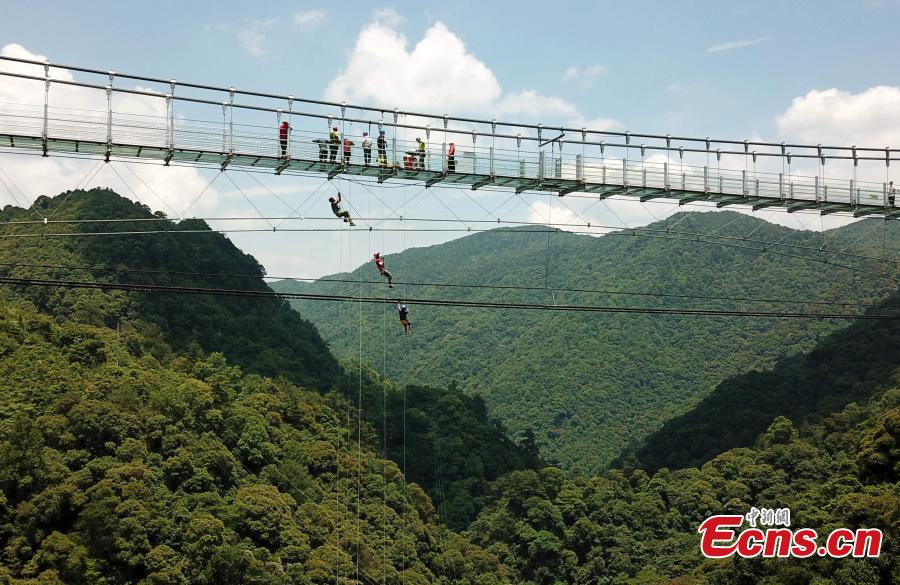 Extreme sports enthusiasts take on the challenge of descending from and then climbing back to a suspended glass bridge 188 meters above the ground at a scenic spot in Youxi County, East China’s Fujian Province, May 26, 2018. More than 20 participants fast-roped down and then climbed back up from under the bottom of the bridge. (Photo: China News Service/Wang Dongming)