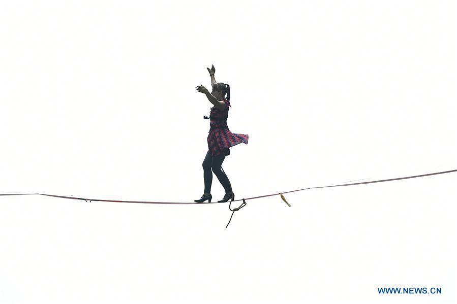 Faith Dickey of the U.S. participates in a slackline contest in high heels in Zhangjiajie, central China\'s Hunan Province, May 27, 2018. (Xinhua/Shao Ying)