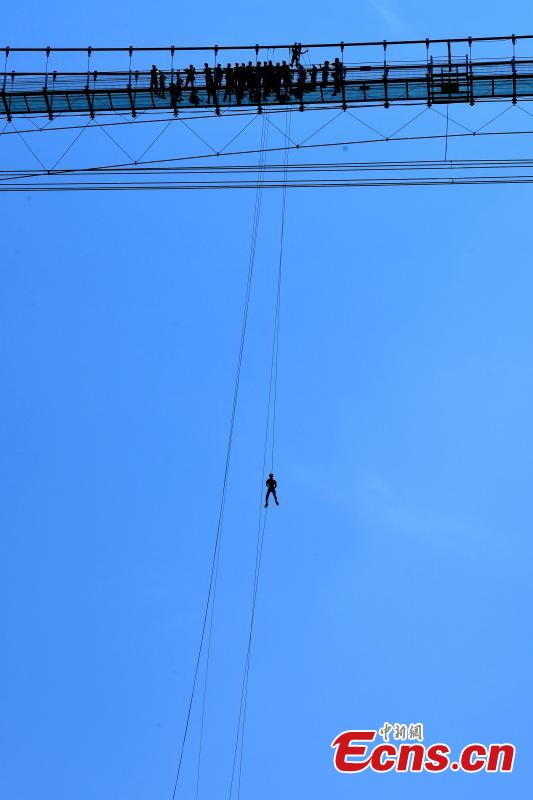 Extreme sports enthusiasts take on the challenge of descending from and then climbing back to a suspended glass bridge 188 meters above the ground at a scenic spot in Youxi County, East China’s Fujian Province, May 26, 2018. More than 20 participants fast-roped down and then climbed back up from under the bottom of the bridge. (Photo: China News Service/Wang Dongming)