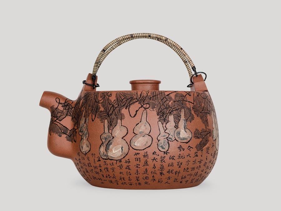 Artist Huang Yongyu is known for his great vigor and versatility. He paints, writes, designs, creates prints and draws comics. And at 94, he has fallen into a new habit of art creation: carving figures on earthen zisha teapots. (Photo provided to China Daily)