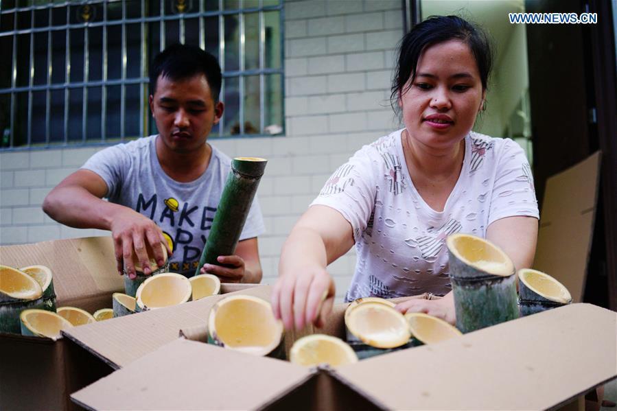 Villagers package bamboo wine at Daliu Village, Longji Town, Longsheng County, south China\'s Guangxi Zhuang Autonomous Region, May 30, 2018. Best known for its rich bamboo materials, Longji has developed bamboo wine industry in recent years. The bamboo wine, usually taking three or four months for brewing in growing bamboos, is popular here. (Xinhua/Huang Yongdan)
