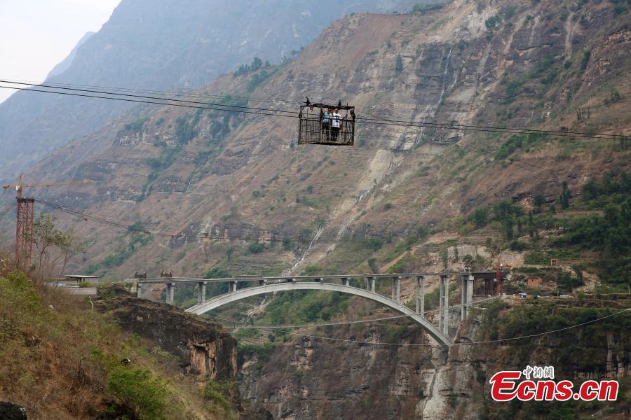 Photo taken on May 30, 2018 shows the Yingge Bridge under construction over the Jinsha River between Yingge Village in Qiaojia County, Yunnan Province and Yanjiang Village in Liangshan Prefecture, Sichuan Province. Construction of the majority of the bridge was completed Wednesday. Until now, a 470-meter cableway 260 meters above the river had served as the main transport option for villagers. It is known as the highest of its kind in Asia. In November 2015, authorities began building the bridge to improve local transport. The new bridge will be nine meters wide, 385.5 meters long, and 200 meters above the river. (Photo: China News Service/Yan Keren)