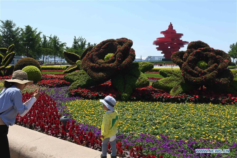 Tourists take photos at the May Fourth Square in Qingdao, east China\'s Shandong Province, May 31, 2018. The 18th Shanghai Cooperation Organization (SCO) Summit is scheduled for June 9-10 in Qingdao. (Xinhua/Zhu Zheng)