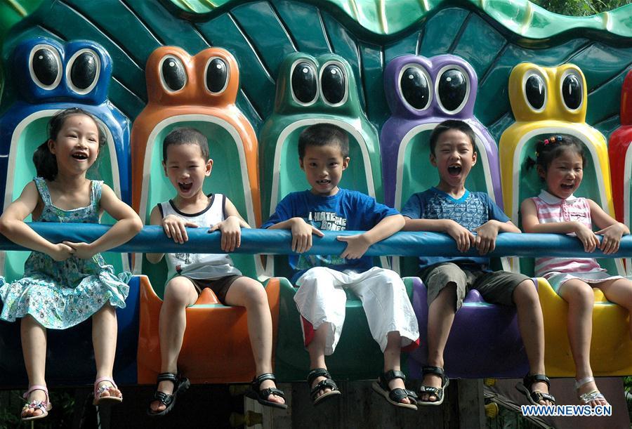 In this file photo taken on July 28, 2006, children ride a thrill machine at an amusement park in Hangzhou, east China\'s Zhejiang Province. As China celebrates the International Children\'s Day, there arises the occasion for grown-ups to think back over the joys of childhood. With the evolution of technology and lifestyle, children are exposed to a wider range of entertainment. Nevertheless, joy would remain a childhood motif no matter how its forms change with time. (Xinhua/Shao Quanda)