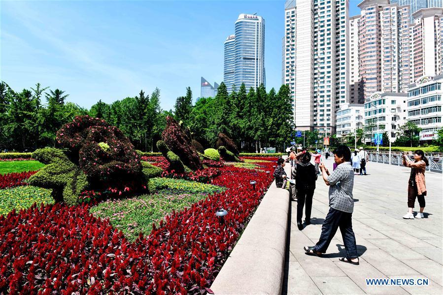 Tourists take photos at the May Fourth Square in Qingdao, east China\'s Shandong Province, May 31, 2018. The 18th Shanghai Cooperation Organization (SCO) Summit is scheduled for June 9-10 in Qingdao. (Xinhua/Guo Xulei)
