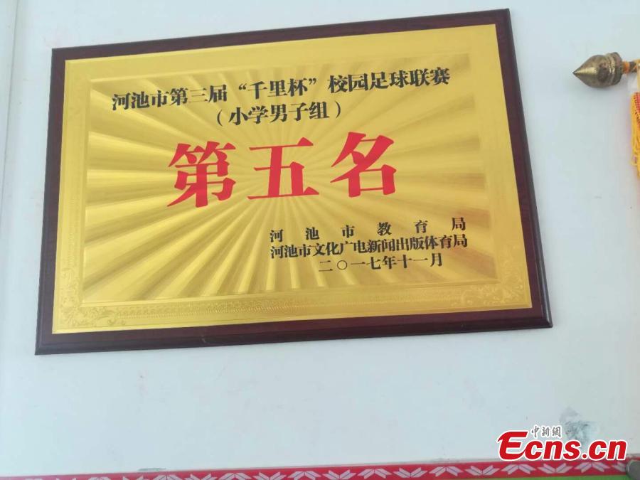 A certificate congratulates the Liuye Central Elementary School boys football team on their fifth placing in Hechi City, Guangxi Zhuang Autonomous Region in 2017. The mountainous county, with a population of 400,000 people, is one the poorest in the region. (Photo: China News Service/Jiang Xuelin)