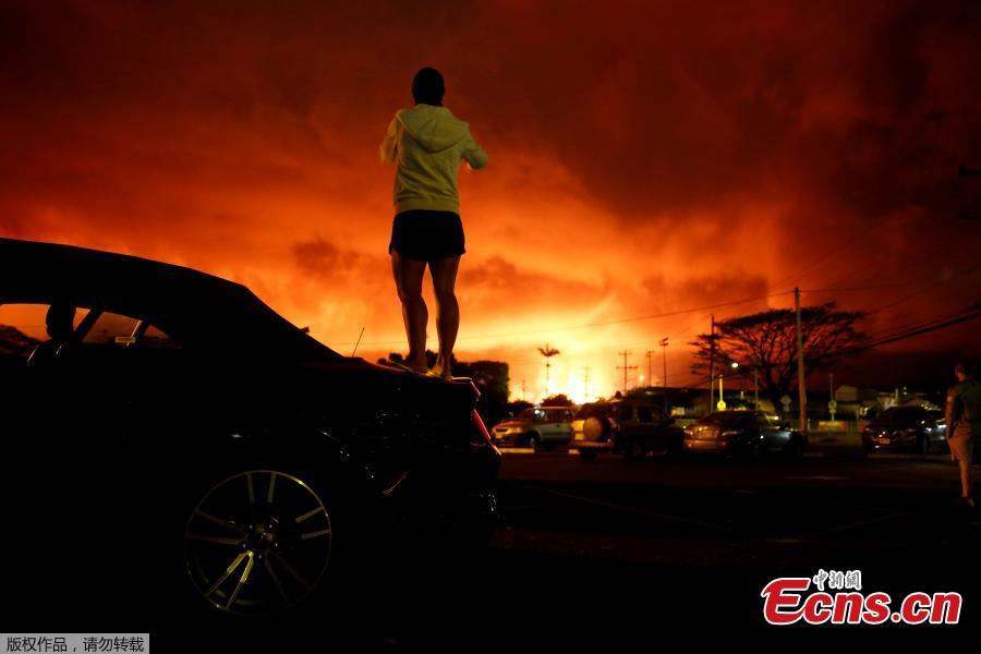 Lara Jackson, 34, of Manchester, Britain, takes a photo as lava lights up the sky above Pahoa during ongoing eruptions of the Kilauea Volcano in Hawaii, U.S., June 2, 2018. (Photo/Agencies)