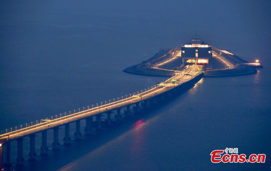 A view of part of the Hong Kong-Zhuhai-Macao Bridge, illuminated at night. The 55-kilometer Hong Kong-Zhuhai-Macao Bridge, the world\'s longest sea bridge, will slash the travel time between Hong Kong and Zhuhai from three hours to just 30 minutes, further integrating cities in the Pearl River Delta. (Photo: China News Service/Sheung Man Mak)