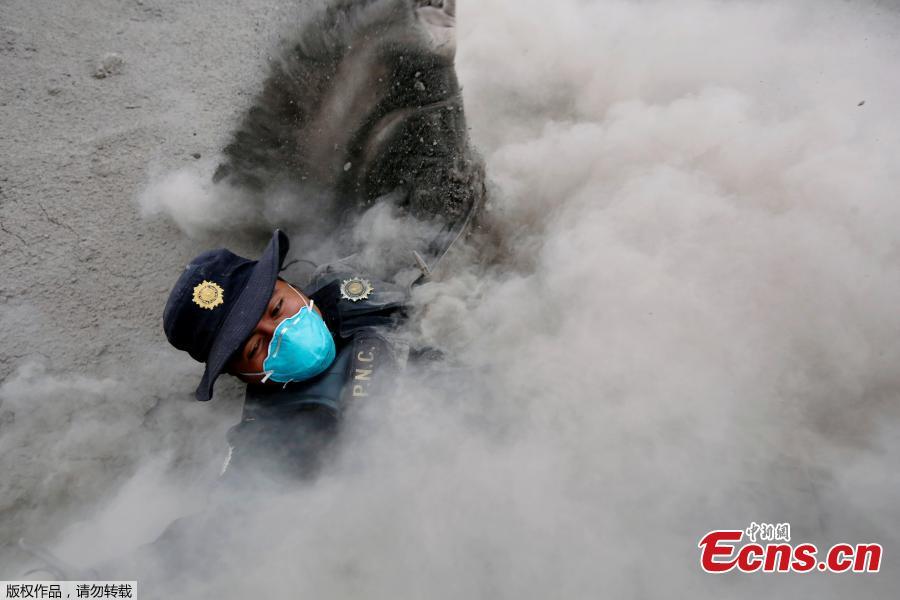 A police officer stumbles while running away from a new pyroclastic flow spewed by the Fuego volcano in the community of San Miguel Los Lotes in Escuintla, Guatemala, June 4, 2018. An estimated 25 people, including at least three children, were killed and nearly 300 injured on Sunday in the most violent eruption of Guatemala’s Fuego volcano in more than four decades, officials said. (Photo/Agencies)