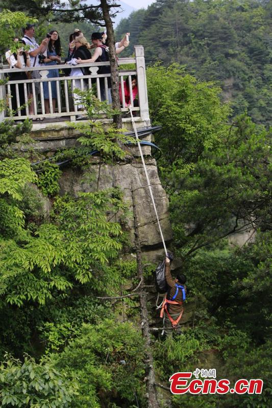Sanitary worker Liu Wenhua collects garbage on a cliff while hanging from a cable at Wulingyuan scenic area in Zhangjiajie City, Central China’s Hunan Province, June 5, 2018. Liu, 48, has worked at the tourist attraction for nearly five years, mainly responsible for cleaning litter left by irresponsible visitors. (Photo: China News Service/Wu Yongbing)