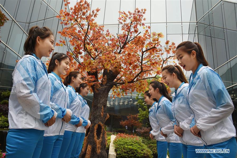 Eight etiquette volunteers for the 18th Shanghai Cooperation Organization (SCO) Summit practice in Qingdao, east China\'s Shandong Province, June 5, 2018. More than 20,000 volunteers have been mobilized to offer services for the summit, from assisting with guests\' arrival and departure, translation, and media requests, to the operation of city functions such as transportation, telecommunication, and banks. (Xinhua/Li Ziheng)