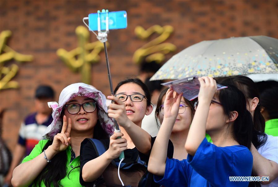 Examinees take a selfie with their family before the national college entrance examination outside an exam venue in Changchun, northeast China\'s Jilin Province, June 7, 2018. About 9.75 million students have registered for the national college entrance examination, which takes place from June 7 to 8. (Xinhua/Lin Hong)