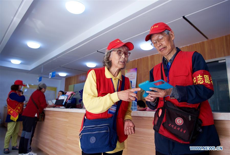 Jiang Shifa (R) and his wife Lian Shifang, volunteers for the Shanghai Cooperation Organization (SCO) Qingdao Summit, gather at Mingxialu Community for training in Qingdao, east China\'s Shandong Province, June 5, 2018. Jiang, 74 years old and his wife, 72 years old, have been volunteers for over ten years after retired from work. The couple feel thrilled to be volunteers for the upcoming SCO Qingdao Summit ten years after they served as volunteers for the Beijing 2008 Olympic Games Sailing event in Qingdao. (Xinhua/Jiang Kehong)