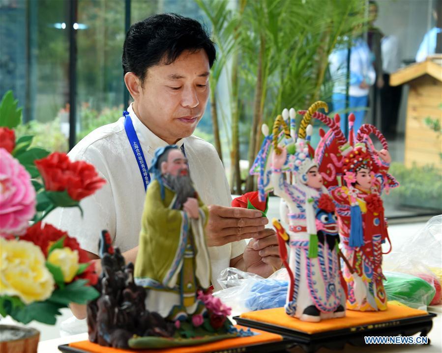 Craftsman Mu Xujian makes dough sculptures at the media center for the 18th Shanghai Cooperation Organization (SCO) Summit in Qingdao, east China\'s Shandong Province, June 6, 2018. (Xinhua/Li Ziheng)