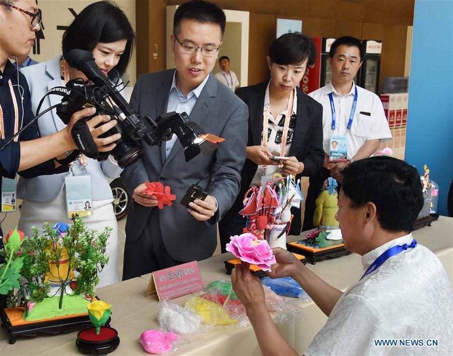 Craftsman Mu Xujian shows dough sculpture making to journalists at the media center for the 18th Shanghai Cooperation Organization (SCO) Summit in Qingdao, east China\'s Shandong Province, June 6, 2018. (Xinhua/Guo Xulei)