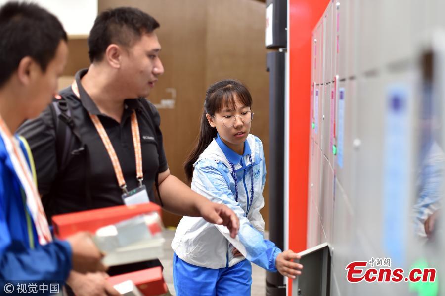 Volunteers work at the press center of the Shanghai Cooperation Organization Qingdao Summit in Qingdao City, East China’s Shandong Province, June 7, 2018. Some 370 volunteers from four universities in Qingdao are assisting journalists from home and abroad at the press center. (Photo/VCG)