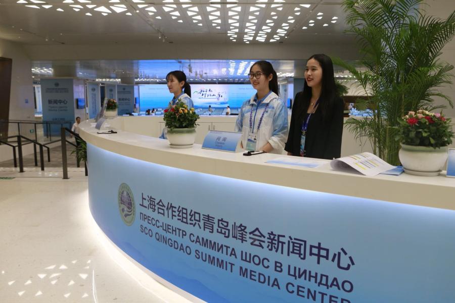Volunteers work at the media center reception desk of the 18th Shanghai Cooperation Organization Summit in Qingdao, East China\'s Shandong Province, on June 7, 2018. (Photo: Li Hao/GT)