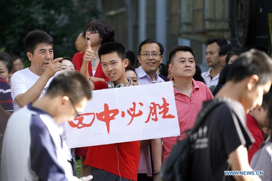 A student encourages examinees at an exam venue in Beijing, capital of China, June 7, 2018. About 9.75 million students have registered for the national college entrance examination, which takes place from June 7 to 8. (Xinhua/Shen Bohan)