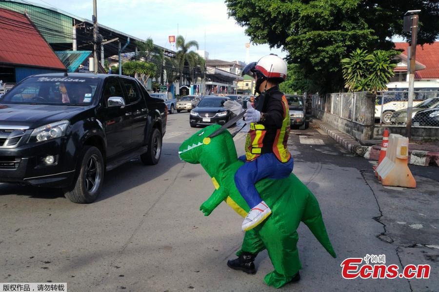 Thai police sergeant Tanit Bussabong directs traffic wearing a costume where he appears to ride a T-rex dinosaur outside a school in Nakhon Nayok on June 4, 2018. Bussabong, who has around 20 different outfits including Minnie Mouse and a bear for his traffic duty outside the kindergarten, said his prehistoric uniform is teaching kids road safety and convincing parents to obey traffic laws.  (Photo/Agencies)